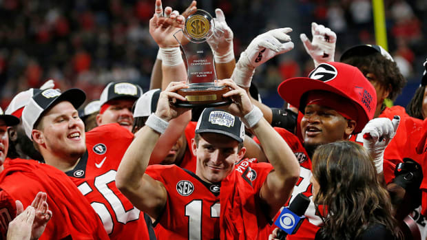 Georgia quarterback Stetson Bennett raises the SEC Championship MVP trophy after a victory against LSU.